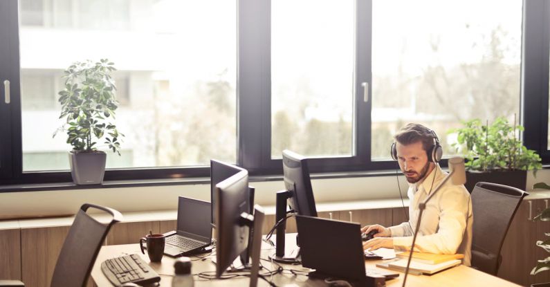 Services - Man With Headphones Facing Computer Monitor