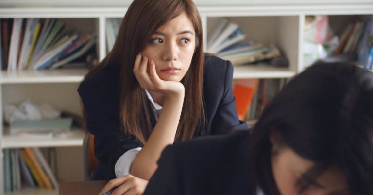 Distractions - Woman Holding Chin Sitting Beside Table in Room